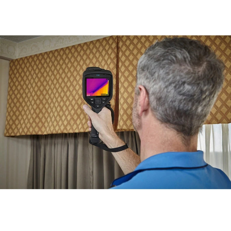 Person using a FLIR E86 thermal imaging camera in an indoor setting