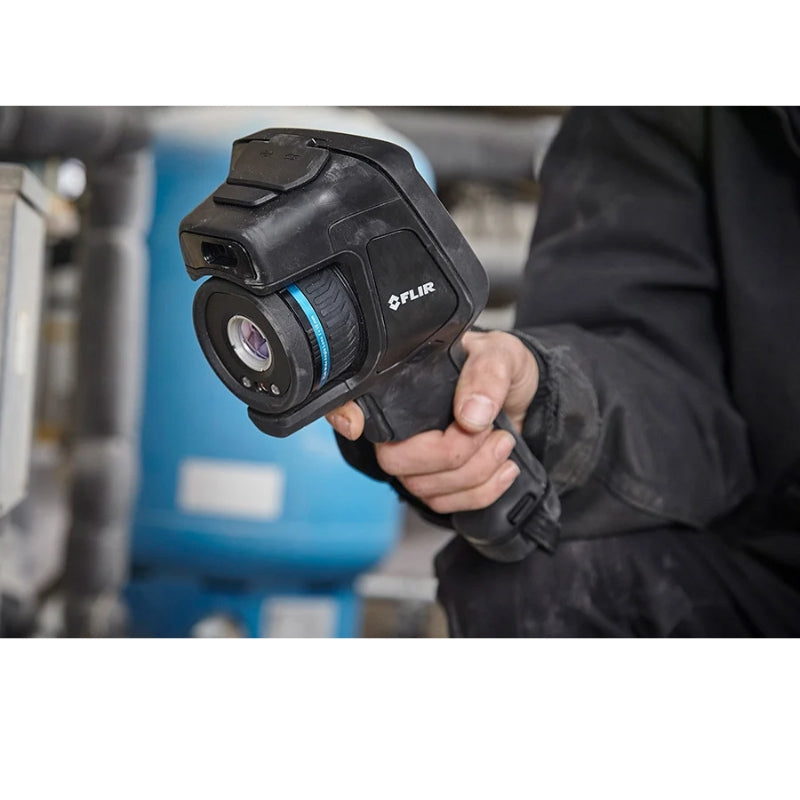 FLIRE86 Person holding a FLIR thermal imaging camera in an industrial setting