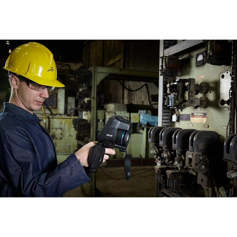 FLIRE86 Person in a hard hat holding a device in an industrial setting